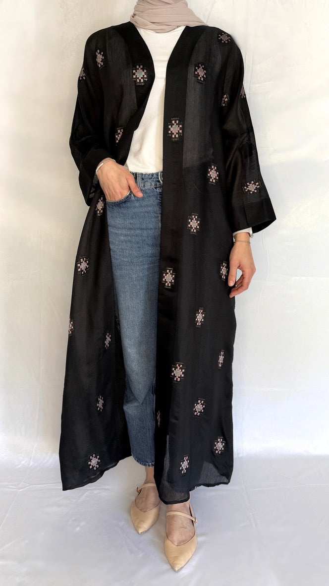 open blck abaya paired with jeans